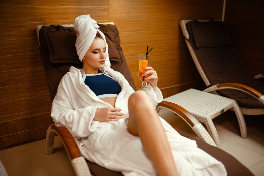 Sexy lady relaxing with cocktail in spa chair
